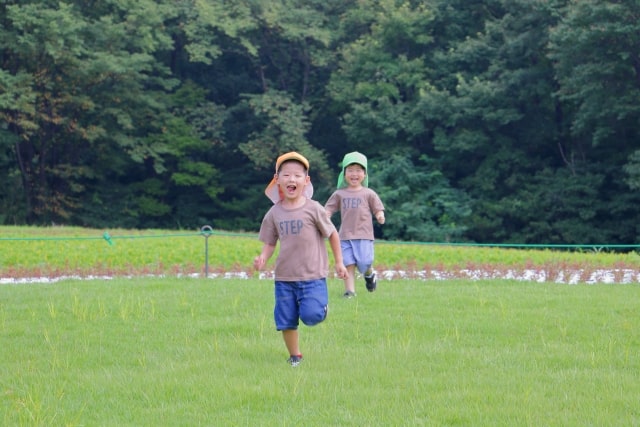草原を走る男の子二人